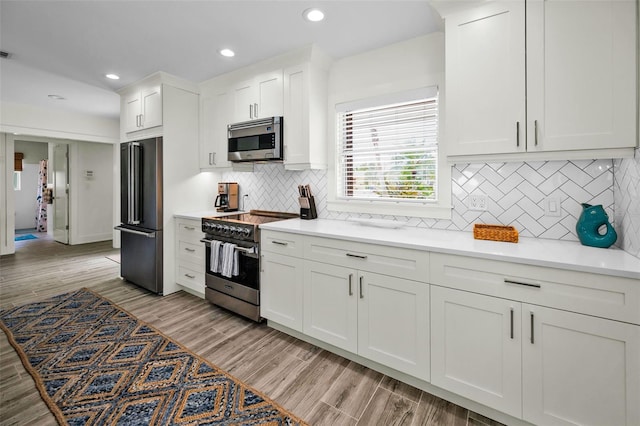 4381 Poinsettia Dr, St Pete Beach, FL 33706 - kitchen featuring stainless steel appliances, white cabinetry, recessed lighting, light countertops, and tasteful backsplash