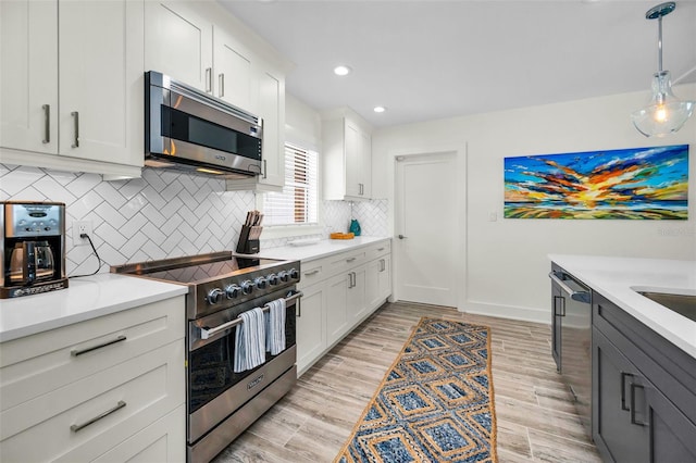 4381 Poinsettia Dr, St Pete Beach, FL 33706 - kitchen featuring stainless steel appliances, light countertops, decorative backsplash, white cabinets, and recessed lighting