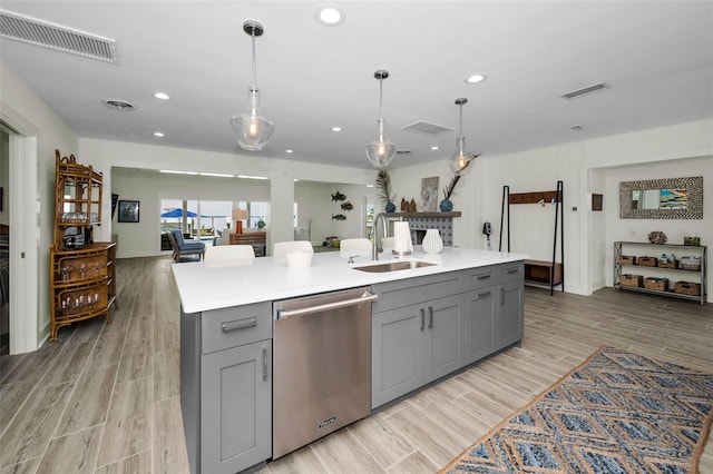 4381 Poinsettia Dr, St Pete Beach, FL 33706 - kitchen with stainless steel dishwasher, gray cabinets, light wood-type flooring, light countertops, and recessed lighting