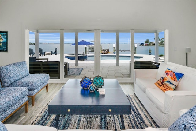 4381 Poinsettia Dr, St Pete Beach, FL 33706 - living area featuring wood finished floors, a water view, and healthy amount of natural light
