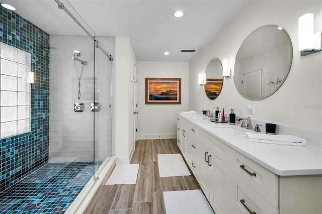 4381 Poinsettia Dr, St Pete Beach, FL 33706 - bathroom featuring a shower stall, double vanity, wood finished floors, and recessed lighting