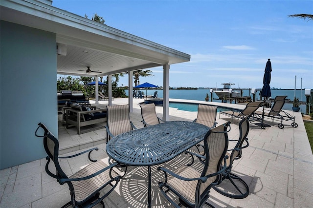 4381 Poinsettia Dr, St Pete Beach, FL 33706 - view of patio / terrace with a ceiling fan, an outdoor pool, outdoor dining area, and a water view