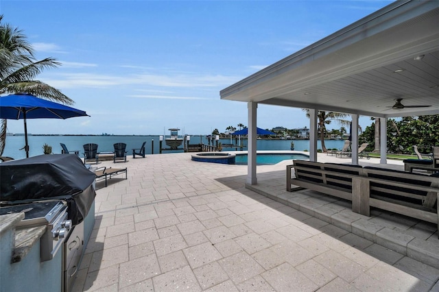 4381 Poinsettia Dr, St Pete Beach, FL 33706 - view of patio with a ceiling fan, a pool with connected hot tub, and a water view