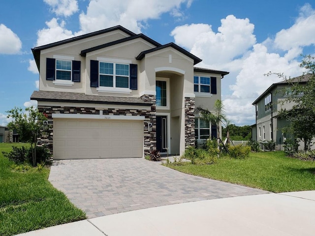 38120 Shale Stone Ct, Zephyrhills, FL 33540 - view of front of property featuring stucco siding, stone siding, decorative driveway, a front yard, and a garage