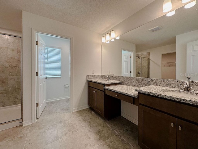 38120 Shale Stone Ct, Zephyrhills, FL 33540 - bathroom featuring a stall shower, two vanities, a walk in closet, and tile patterned flooring