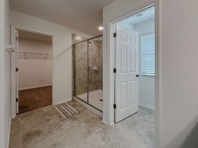 38120 Shale Stone Ct, Zephyrhills, FL 33540 - bathroom featuring a shower stall, a walk in closet, and tile patterned floors