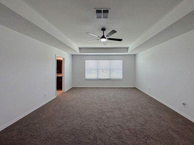38120 Shale Stone Ct, Zephyrhills, FL 33540 - spare room with ceiling fan, a textured ceiling, carpet flooring, and a tray ceiling