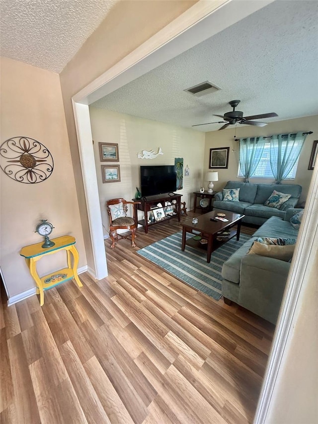 1814 Driftwood Cir S, Oldsmar, FL 34677 - living room featuring a textured ceiling, light wood-style flooring, and ceiling fan