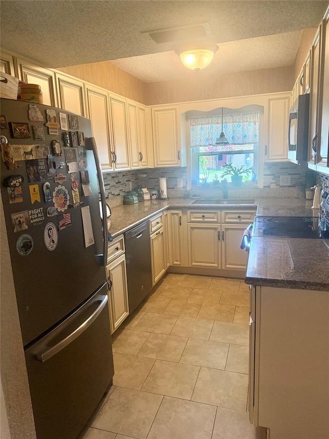 1814 Driftwood Cir S, Oldsmar, FL 34677 - kitchen featuring appliances with stainless steel finishes, backsplash, a textured ceiling, dark stone countertops, and light tile patterned floors