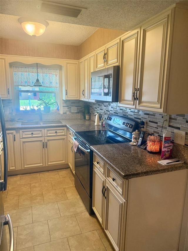 1814 Driftwood Cir S, Oldsmar, FL 34677 - kitchen featuring black electric range, stainless steel microwave, decorative backsplash, a textured ceiling, and light tile patterned floors