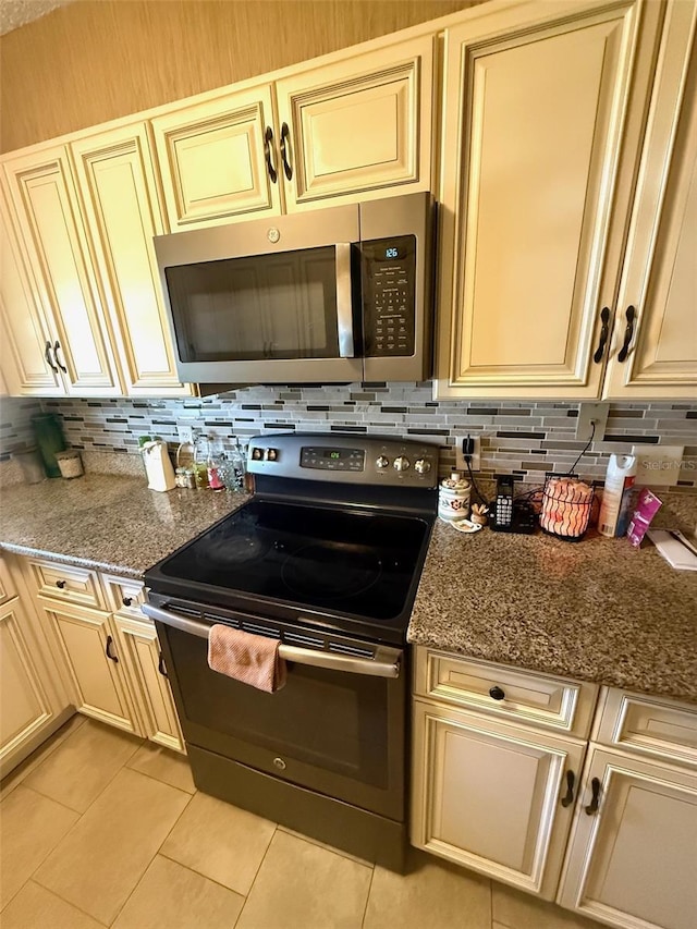 1814 Driftwood Cir S, Oldsmar, FL 34677 - kitchen featuring appliances with stainless steel finishes, cream cabinets, tasteful backsplash, and light tile patterned floors