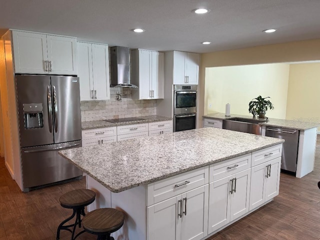 2005 Capri Rd, Valrico, FL 33594 - kitchen with appliances with stainless steel finishes, wall chimney range hood, dark wood finished floors, a kitchen island, and recessed lighting