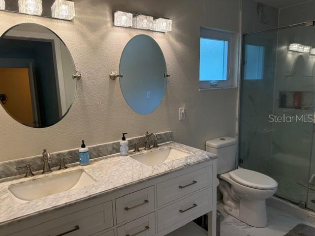 2005 Capri Rd, Valrico, FL 33594 - bathroom with double vanity, a shower stall, and marble finish flooring