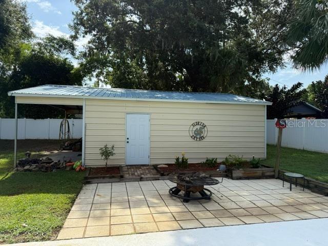 2005 Capri Rd, Valrico, FL 33594 - view of patio / terrace with an outdoor fire pit and an outdoor structure