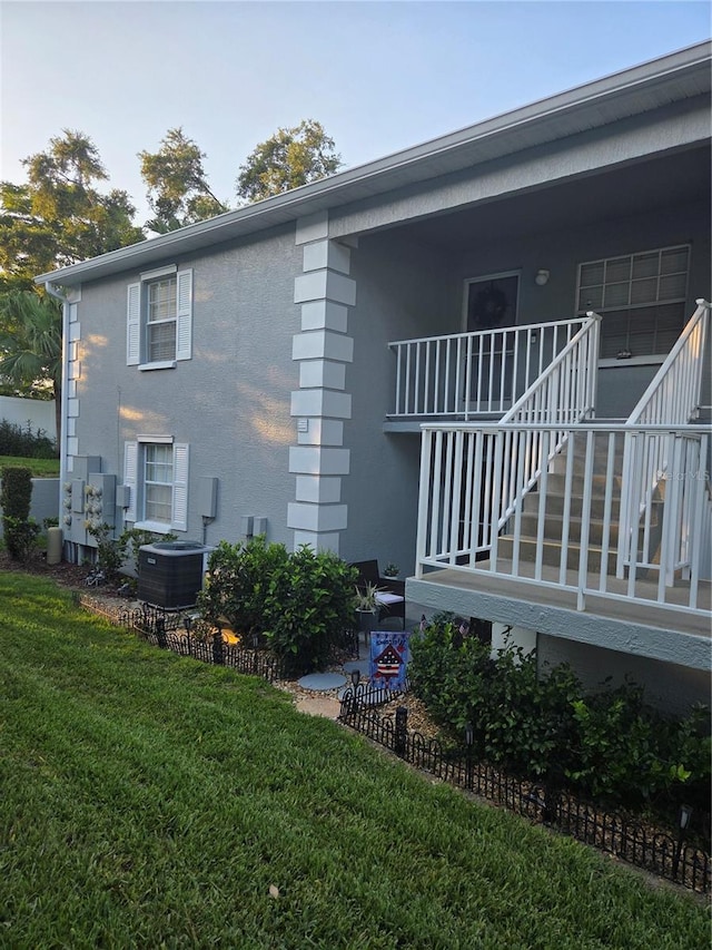12133 Spartan Way Unit 203, Hudson, FL 34667 - view of side of property with stairs, stucco siding, and a lawn
