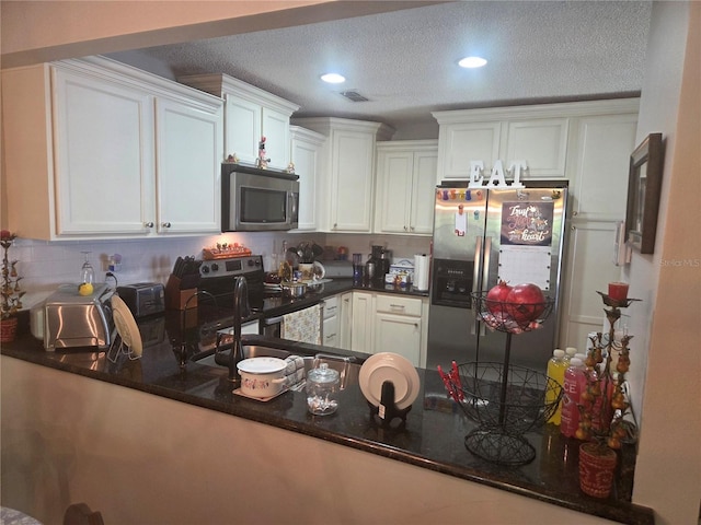 12133 Spartan Way Unit 203, Hudson, FL 34667 - kitchen with appliances with stainless steel finishes, recessed lighting, tasteful backsplash, white cabinets, and a textured ceiling