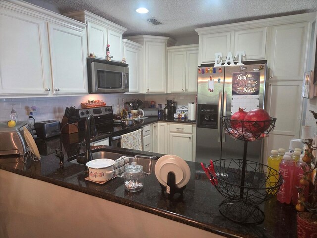 12133 Spartan Way Unit 203, Hudson, FL 34667 - kitchen featuring stainless steel appliances, decorative backsplash, white cabinets, and dark stone counters