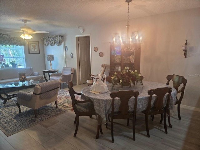 12133 Spartan Way Unit 203, Hudson, FL 34667 - dining area with wood finished floors, a chandelier, a textured ceiling, and ceiling fan