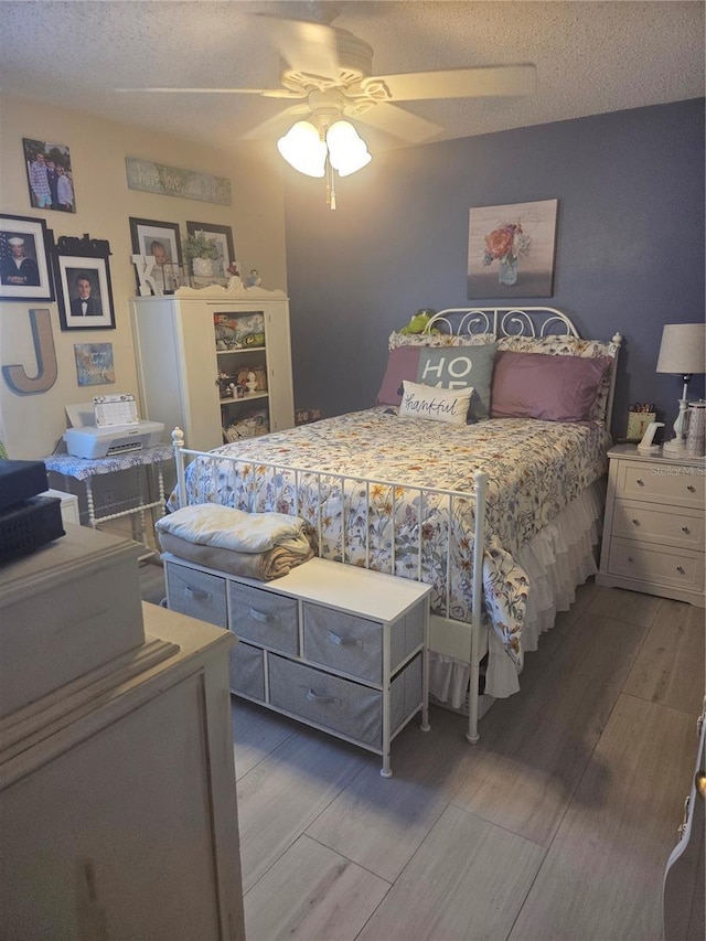 12133 Spartan Way Unit 203, Hudson, FL 34667 - bedroom featuring wood finished floors, a ceiling fan, and a textured ceiling