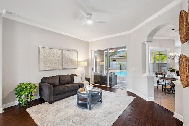 31646 Baymont Loop, Wesley Chapel, FL 33543 - living room featuring a ceiling fan, dark wood finished floors, arched walkways, ornamental molding, and decorative columns