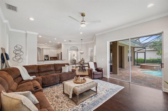 31646 Baymont Loop, Wesley Chapel, FL 33543 - living area with a ceiling fan, dark wood-type flooring, arched walkways, ornamental molding, and recessed lighting