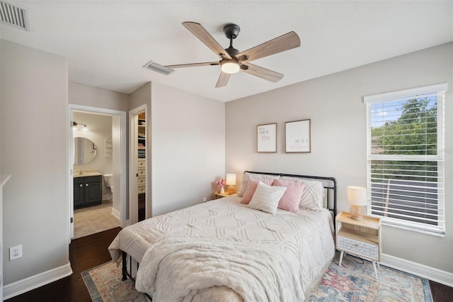 31646 Baymont Loop, Wesley Chapel, FL 33543 - bedroom with dark wood-style floors, ensuite bathroom, and a ceiling fan
