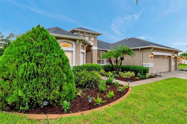 31646 Baymont Loop, Wesley Chapel, FL 33543 - view of front of home with stucco siding, an attached garage, a front lawn, and concrete driveway
