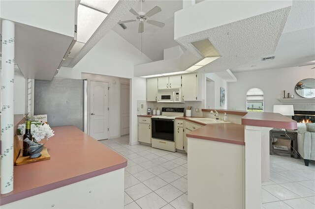 18561 Winding Oaks Blvd, Hudson, FL 34667 - kitchen with white appliances, a peninsula, ceiling fan, open floor plan, and light tile patterned flooring