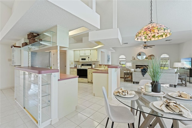 18561 Winding Oaks Blvd, Hudson, FL 34667 - dining room featuring a ceiling fan, a warm lit fireplace, and light tile patterned flooring