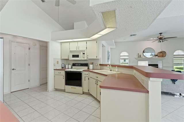 18561 Winding Oaks Blvd, Hudson, FL 34667 - kitchen with white appliances, a ceiling fan, a peninsula, light tile patterned floors, and a textured ceiling
