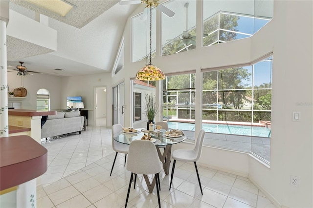 18561 Winding Oaks Blvd, Hudson, FL 34667 - tiled dining area featuring ceiling fan, a towering ceiling, and a textured ceiling