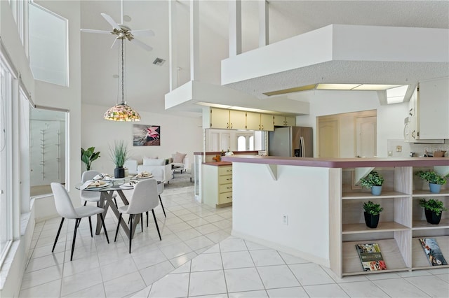 18561 Winding Oaks Blvd, Hudson, FL 34667 - kitchen with high vaulted ceiling, stainless steel refrigerator with ice dispenser, ceiling fan, a peninsula, and cream cabinets