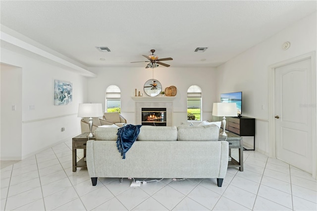 18561 Winding Oaks Blvd, Hudson, FL 34667 - living room with ceiling fan, light tile patterned floors, and a glass covered fireplace