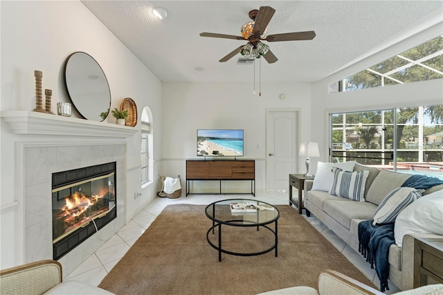 18561 Winding Oaks Blvd, Hudson, FL 34667 - living room with tile patterned floors, a ceiling fan, a tile fireplace, and a textured ceiling