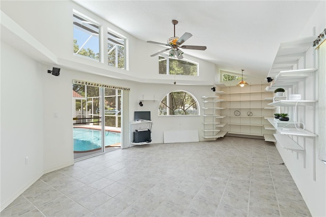 18561 Winding Oaks Blvd, Hudson, FL 34667 - unfurnished living room featuring a ceiling fan, healthy amount of natural light, high vaulted ceiling, and light tile patterned floors