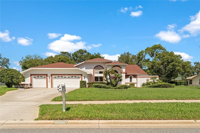 18561 Winding Oaks Blvd, Hudson, FL 34667 - mediterranean / spanish-style house with a garage, driveway, a front yard, stucco siding, and a tile roof