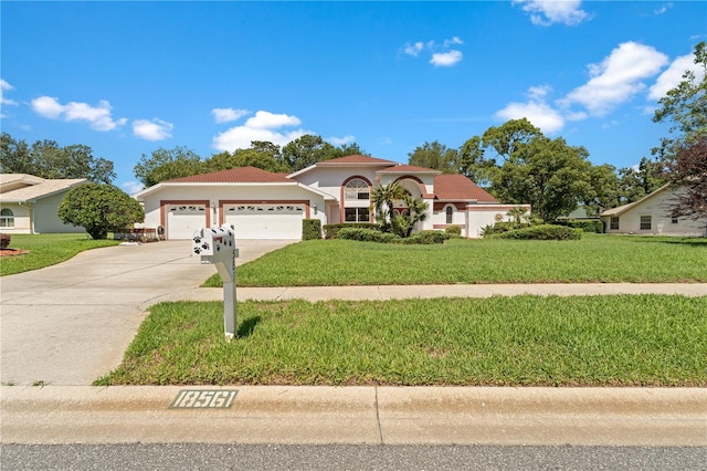 18561 Winding Oaks Blvd, Hudson, FL 34667 - mediterranean / spanish house featuring an attached garage, concrete driveway, a front lawn, and stucco siding
