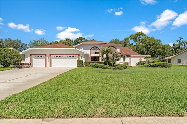 18561 Winding Oaks Blvd, Hudson, FL 34667 - view of front facade featuring a garage, driveway, a front lawn, stucco siding, and a tile roof