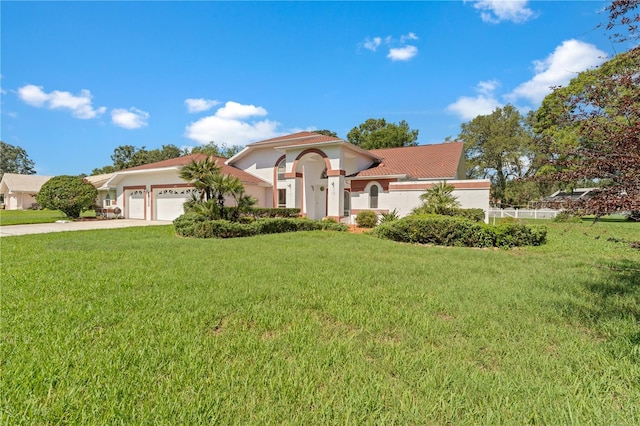 18561 Winding Oaks Blvd, Hudson, FL 34667 - mediterranean / spanish-style home featuring an attached garage, stucco siding, driveway, a front lawn, and a tile roof
