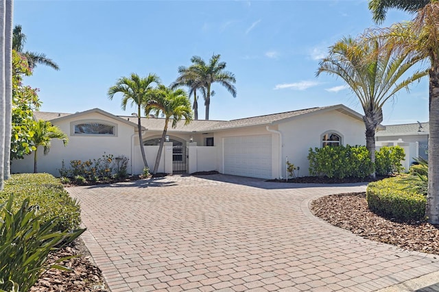 11225 4th St E, Treasure Island, FL 33706 - ranch-style house featuring stucco siding, curved driveway, and an attached garage