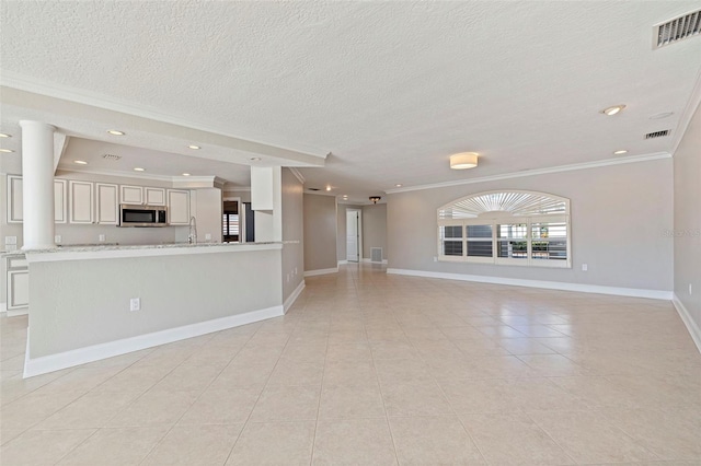 11225 4th St E, Treasure Island, FL 33706 - unfurnished living room with ornamental molding, a textured ceiling, light tile patterned floors, and recessed lighting
