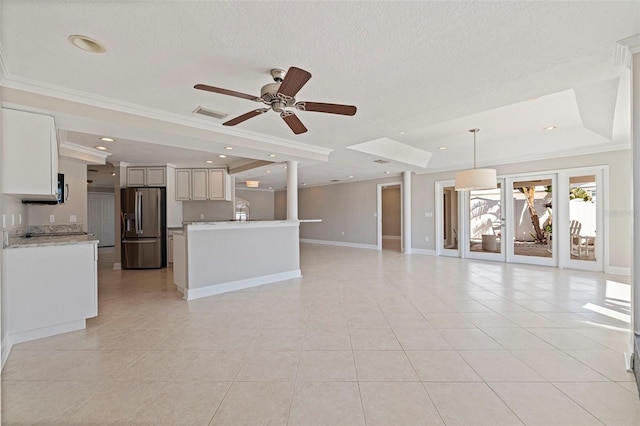 11225 4th St E, Treasure Island, FL 33706 - unfurnished living room featuring a tray ceiling, light tile patterned floors, ornamental molding, a ceiling fan, and a textured ceiling