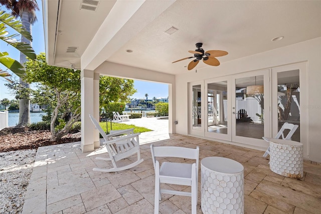 11225 4th St E, Treasure Island, FL 33706 - view of patio with french doors, a water view, and a ceiling fan