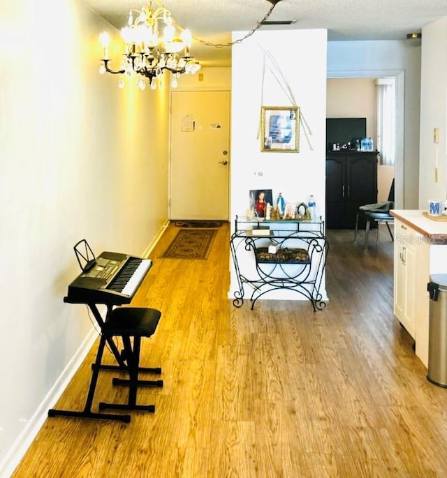 5623 80th St N Unit 406, Saint Petersburg, FL 33709 - corridor with light wood finished floors and a chandelier