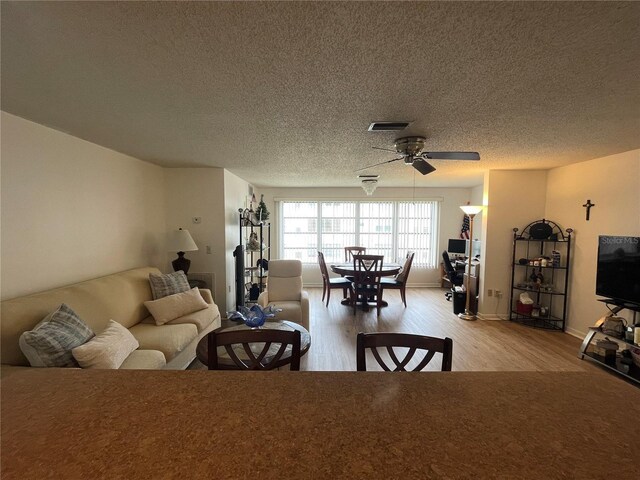 5623 80th St N Unit 406, Saint Petersburg, FL 33709 - living room with light wood-style floors, ceiling fan, and a textured ceiling