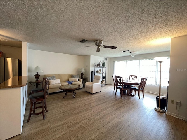 5623 80th St N Unit 406, Saint Petersburg, FL 33709 - living area featuring a ceiling fan, wood finished floors, and a textured ceiling