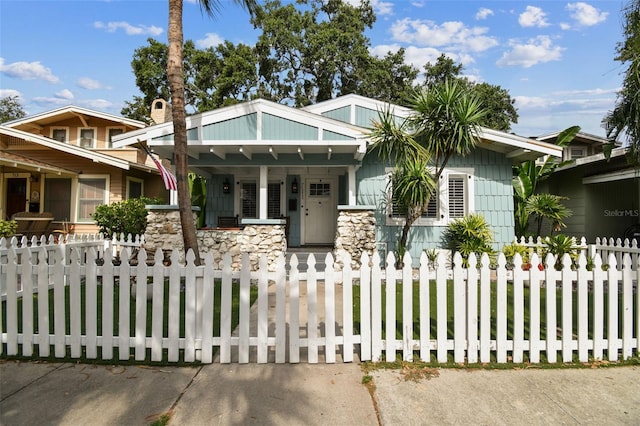 711 S Bungalow Ter, Tampa, FL 33606 - craftsman house featuring a porch, a fenced front yard, and stone siding