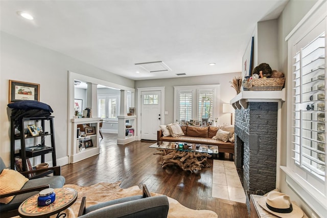 711 S Bungalow Ter, Tampa, FL 33606 - living area featuring a stone fireplace, healthy amount of natural light, hardwood / wood-style flooring, decorative columns, and recessed lighting