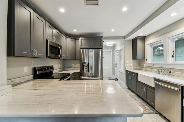 711 S Bungalow Ter, Tampa, FL 33606 - kitchen with appliances with stainless steel finishes, recessed lighting, light stone countertops, and a peninsula