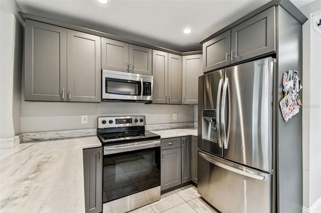 711 S Bungalow Ter, Tampa, FL 33606 - kitchen featuring appliances with stainless steel finishes, light stone countertops, recessed lighting, and gray cabinets